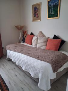 a bedroom with a large bed with red and white pillows at Bedrock Accommodation in Gansbaai