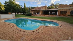 a large swimming pool in a yard with a house at Grobler's Haven On Vaal - Barrage in Tumahole