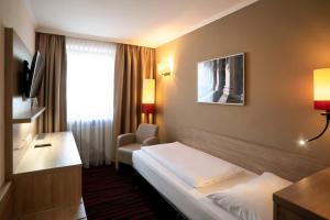 a hotel room with a bed and a window at Europäischer Hof in Munich