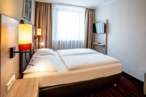 a hotel room with a bed and a window at Europäischer Hof in Munich