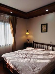 a bedroom with a large bed and a window at À Lôi Homestay Đồng Văn in Dồng Văn