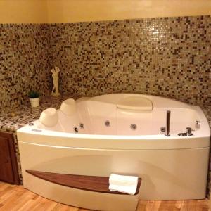 y baño con bañera blanca y pared de azulejos. en St. Peter Luxury Inn, en Roma