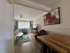a living room with a wooden table and a living room with a couch at Spacious 5 Bedroom House Addlestone in Addlestone
