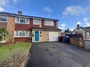 a brick house with a blue door and a driveway at Spacious 5 Bedroom House Addlestone in Addlestone