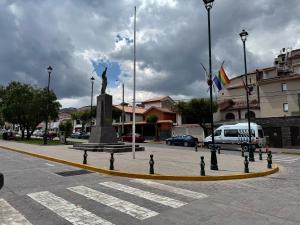 a statue in the middle of a street with flags at Templo de la Luna Pardo in Cusco