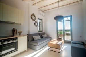a living room with a couch and a table at White Cliff Villas Paros in Ambelas +91 photos