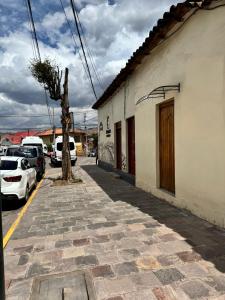 a street with cars parked next to a building at Templo de la Luna Pardo in Cusco