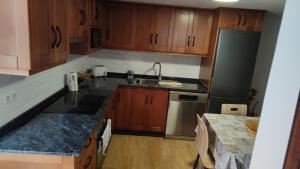 a kitchen with wooden cabinets and stainless steel appliances at Bernal I, II y III in Los Sauces