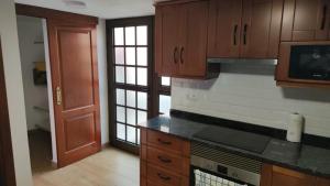 a kitchen with wooden cabinets and a stove top oven at Bernal I, II y III in Los Sauces