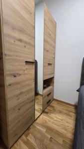 a bedroom with a large wooden closet with a mirror at Apartman Simić in Smederevo