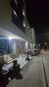 a parking lot in front of a building at night at Apartman Simić in Smederevo