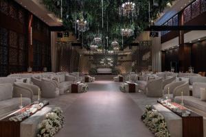 a banquet hall with couches and a table with flowers at Sofitel Al Khobar The Corniche in Al Khobar