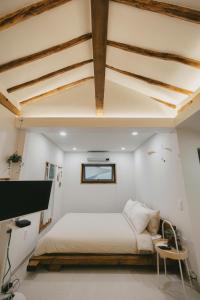 a bedroom with white walls and a bed and a desk at Bow Hanok House in Gangneung