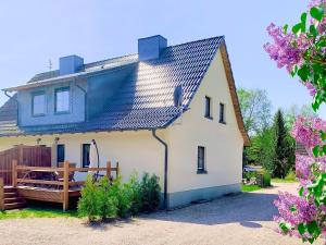 a white house with a blue roof at Ferienwohnung Perle im Grünen - Urlaub an der Müritz in Federow