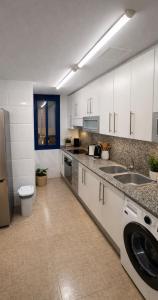 a kitchen with white cabinets and a sink at RelaxMaria in Sant Carles de la Ràpita