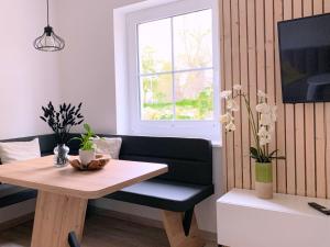 a living room with a table and a couch at Ferienwohnung Perle im Grünen - Urlaub an der Müritz in Federow