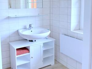 a white bathroom with a sink and a mirror at Ferienwohnung Perle im Grünen - Urlaub an der Müritz in Federow +12 photos