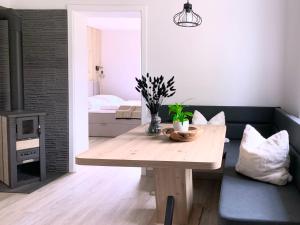 a living room with a wooden table and a couch at Ferienwohnung Perle im Grünen - Urlaub an der Müritz in Federow
