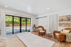 a bedroom with a bed and chairs and a balcony at Redwoods Luxury Sanctuary in Redway