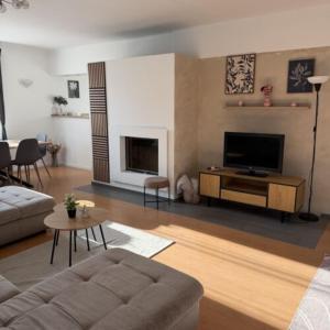 a living room with a couch and a tv at Charlie porta in Abádszalók