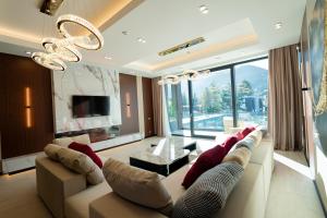 a living room with a couch and a chandelier at Verde by Hotel Gabriela in Vişeu de Sus