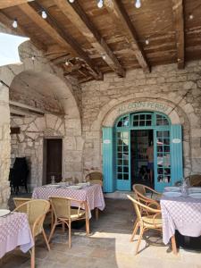 a patio with tables and chairs in a building at au coin perdu in Lauzerte
