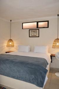 a bedroom with a large bed and two lights at Bougainvilla Kolwezi Guesthouse in Kolwezi