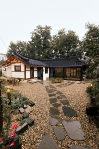 a house with a stone path in front of it at Bow Hanok House in Gangneung
