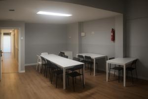 two tables and chairs in a room with white walls at Cozy Nook in Valencia
