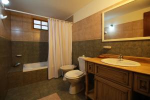 ein Badezimmer mit einem WC, einem Waschbecken und einer Badewanne in der Unterkunft Isla Bella in Ushuaia