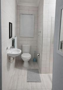 a white bathroom with a toilet and a sink at At last in Pearly Beach +11 photos
