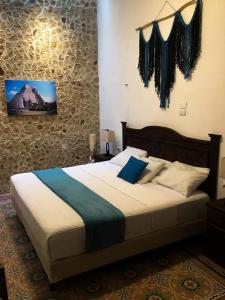 a bedroom with a large bed with blue pillows at Casa Bahareque Merida in Mérida
