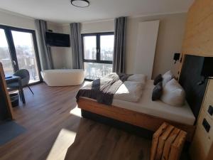a bedroom with a large bed and a bath tub at Landhotel Berggaststätte Bickenriede in Anrode