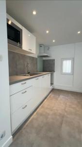 a kitchen with white cabinets and a sink at large downtown studio in Corbeil-Essonnes