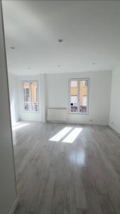 an empty white room with two windows and a wooden floor at large downtown studio in Corbeil-Essonnes +1 photo