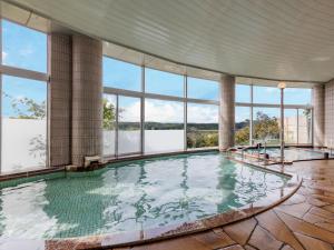 a large indoor swimming pool with large windows at KAMENOI HOTEL Ichinoseki in Ichinoseki