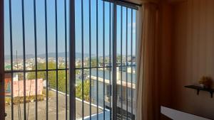 a room with a large window with a view of a city at GRETZbnb in Shillong