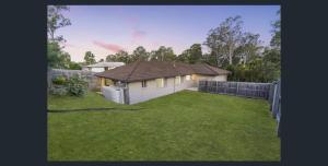 a small house in a yard with a fence at 4 bedrooms with queen sized bed each room in Riverview