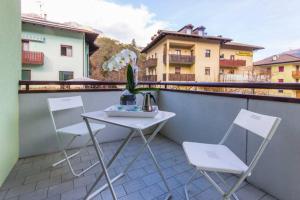 einen Tisch und zwei Stühle auf dem Balkon in der Unterkunft Comano Terme Apart in Comano Terme