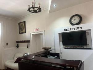a living room with a couch and a clock on the wall at HEBA GUEST LODGE in Uitenhage