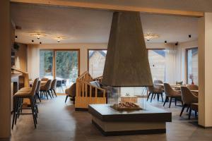 a living room with a fireplace and tables and chairs at Hotel La Müda in Badia