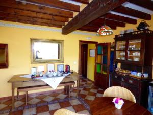 eine Küche mit einem Holztisch und Stühlen im Zimmer in der Unterkunft Posada El Bosque in Mieses