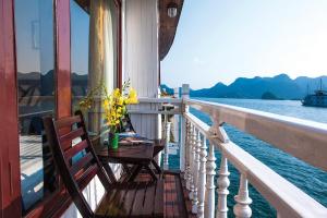 a balcony of a boat with a table and flowers at Royal Palace Cruise in Ha Long +33 photos