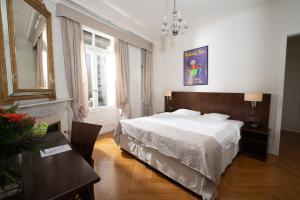 a bedroom with a large white bed and a table at Hotel Helvetie Montreux in Montreux +93 photos