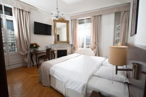 a bedroom with a white bed and a table at Hotel Helvetie Montreux in Montreux