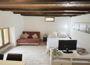 a bedroom with a bed and a desk with a computer at Le Studio du Rhône in Saint-Léonard
