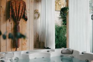 ein Badezimmer mit einer weißen Badewanne und einem Fenster in der Unterkunft Essential by cin in Zonhoven