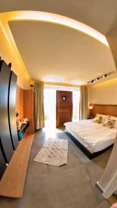 a bedroom with a large bed and a large window at Beit Colette in Beït ed Dîne