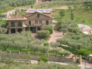 una casa grande en la cima de una colina con árboles en La Ginestra, en Castel San Lorenzo