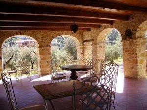 Un patio con una mesa y sillas en un edificio. en La Ginestra, en Castel San Lorenzo